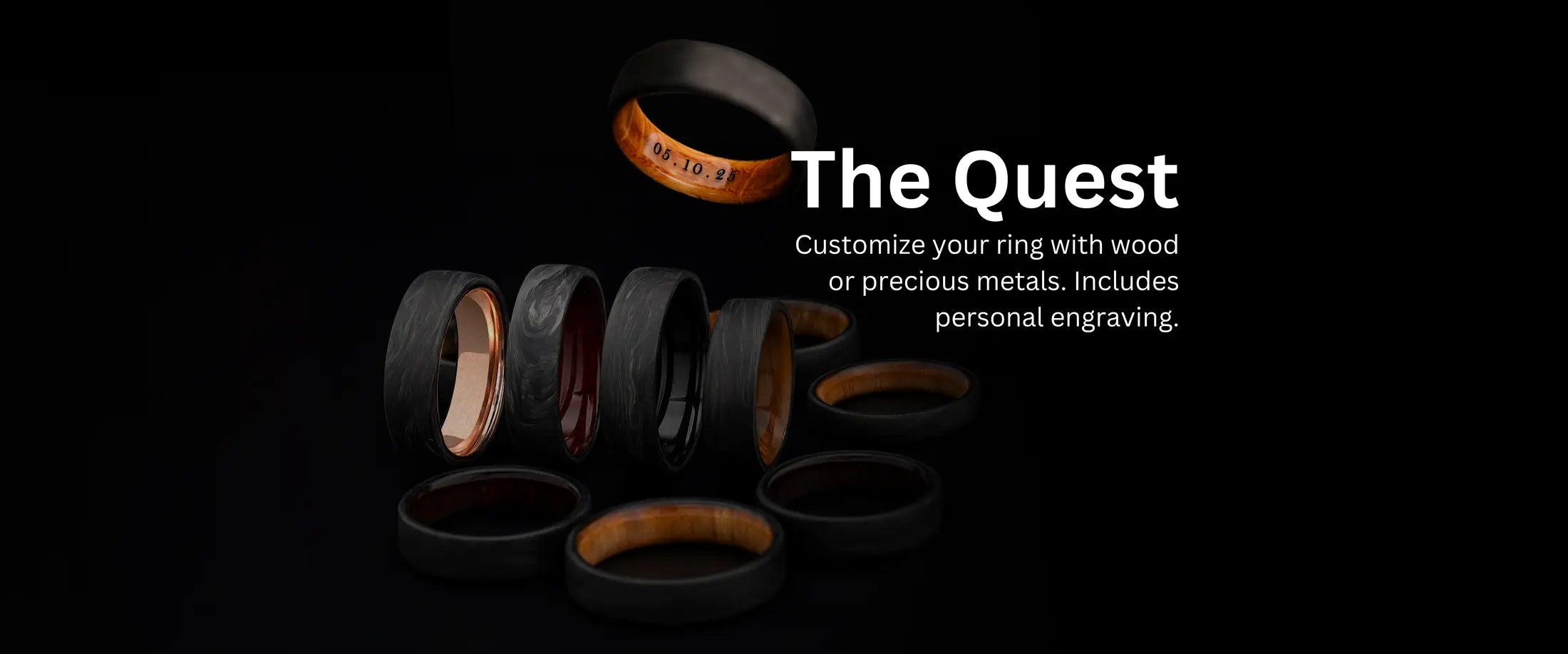 A collection of custom black wedding rings from "The Quest" line, featuring inner inlays of wood and precious metals, with an engraved date on one ring.