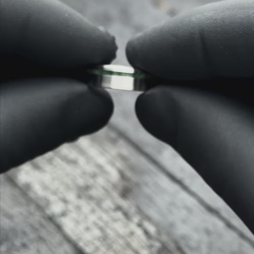 Titanium wedding band with moss agate inlay, 6mm mens ring, brushed flat profile, unique design, free engraving, showcased with black gloves.